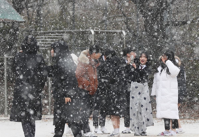 3일 오전 경기도 군포시 산본고등학교에서 학생들이 내리는 눈을 맞으며 즐거워하고 있다. 연합뉴스