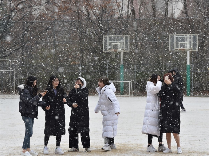 함박눈이 내린 3일 오전 경기 군포시 산본고등학교 운동장에서 학생들이 눈을 맞으며 셀카 촬영을 하고 있다. 뉴시스