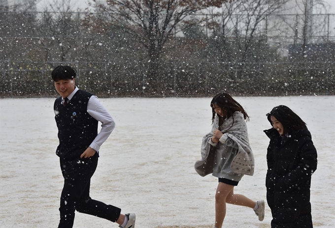 함박눈이 내린 3일 오전 경기 군포시 산본고등학교 운동장에서 학생들이 눈을 맞으며 걷고 있다. 뉴시스