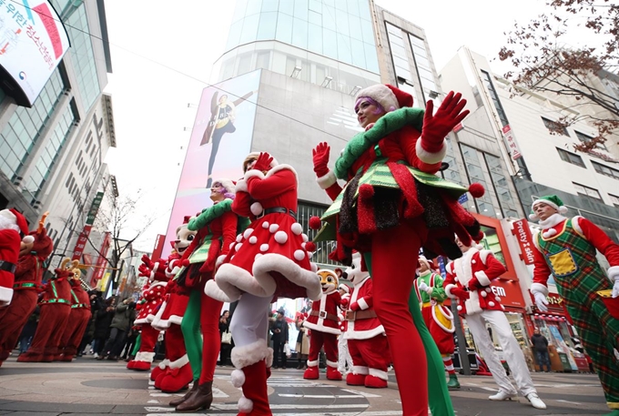 3일 서울 중구 명동에서 에버랜드 대표 캐릭터인 레니와 라라, 산타 마을의 요정 등 연기자들이 '크리스마스 판타지 축제'를 홍보하며 특별 공연을 하는 모습을 한 아이가 보고 있다. 연합뉴스