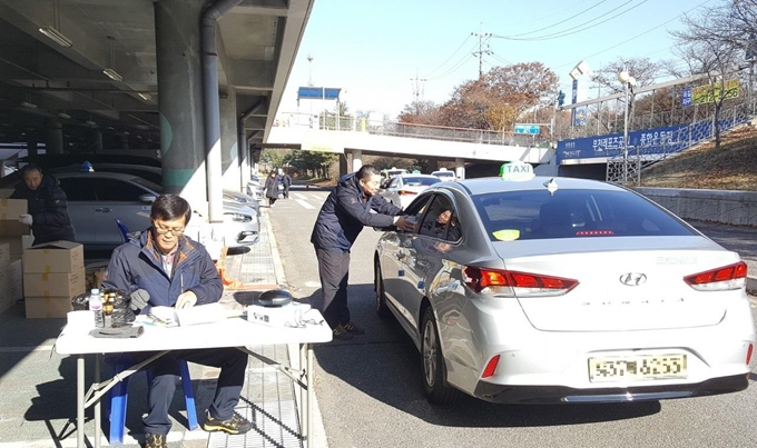 지난달 29일 경기 부천종합운동장 주차장에서 부천개인택시조합이 조합원에게 공기청정기를 지급하고 있다. 부천시 제공