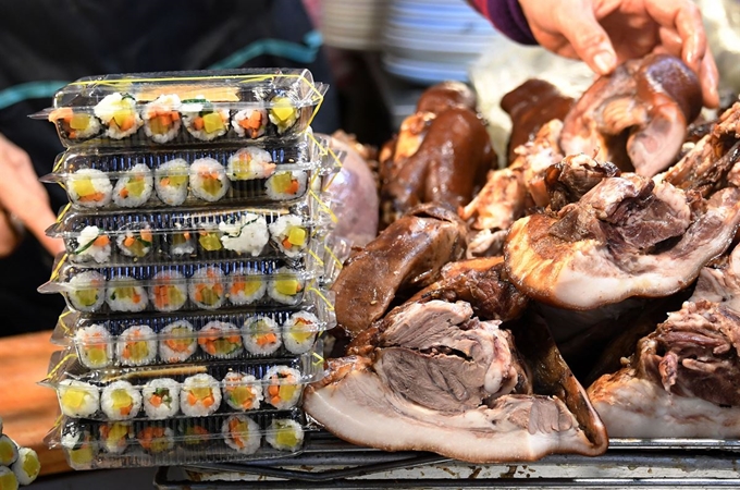 광장시장을 대표하는 음식 중 하나로 마약김밥이 큰 인기를 얻자 마약김밥과 연관이 없는 음식점들이 너도나도 마약김밥을 판매하기 시작했다. 3일 오후 서울 종로구 광장시장 먹거리 거리에 자리한 음식점에 머릿고기와 함께 마약김밥이 진열돼 있다.