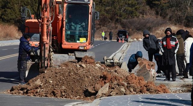 전남 여수시의회 상포지구실태파악특별위원회 소속 의원들이 지난해 1월 돌산읍 상포지구에서 시 도시계획과 담당공무원 등이 참여한 가운데 굴삭기와 우수관로 CCTV 촬영 장비를 동원해 부실시공 현장을 확인하고 있다.