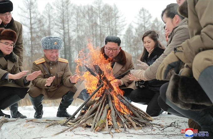 김정은 북한 국무위원장이 군 간부들과 함께 군마를 타고 백두산에 올랐다고 조선중앙통신이 4일 보도했다. 사진은 김 위원장이 간부들과 모닥불을 쬐고 있는 모습으로, 김 위원장 오른쪽에 부인 리설주 여사도 자리하고 있다. 평양=조선중앙통신 연합뉴스