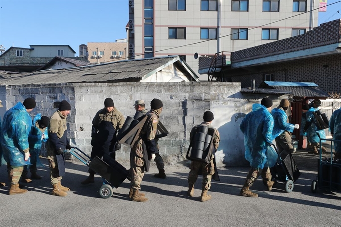 5일 경기도 동두천시 보산동에서 주한미군 2사단 210화력여단 장병들이 지역 소외계층을 위한 연탄을 나르고 있다. 연합뉴스