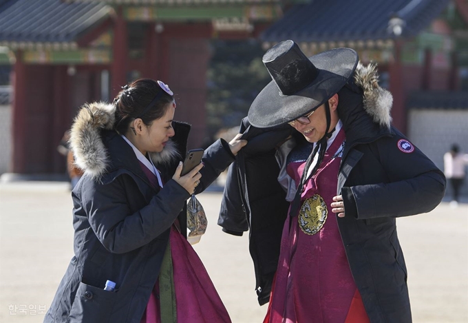 최저기온이 영하 10도까지 떨어진 6일 오전 서울 종로구 경복궁에서 외국인 관광객들이 기념사진을 찍은 후 두꺼운 옷을 다시 입고 있다. 박형기 인턴기자