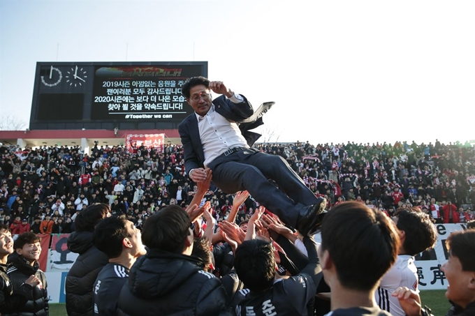 부산 선수들이 8일 창원축구센터에서 열린 하나원큐 K리그 승강 플레이오프에서 경남에 승리를 거둔 뒤 K리그1 승격을 이끈 조덕제 감독을 헹가레 치고 있다. 한국프로축구연맹 제공