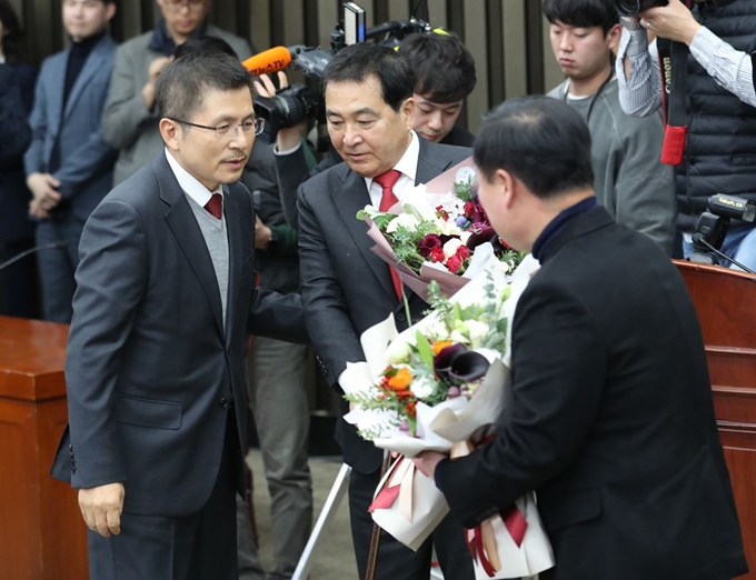 9일 오전 서울 여의도 국회에서 열린 자유한국당 의원총회에서 신임 원내대표로 선출된 심재철 의원(가운데)과 김재원 신임 정책위의장이 황교안 대표로부터 축하받고 있다. 연합뉴스