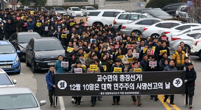 강원대 직원과 조교로 구성된 ‘총장임용후보자 선거 직원 비상대책위원회’가 9일 오후 강원대 춘천캠퍼스 대학본부 앞에서 비민주적 총장임용후보자 선거방식 철회 및 평등선거 쟁취를 위한 결의대회를 열고, 거리행진을 하고 있다. 연합뉴스