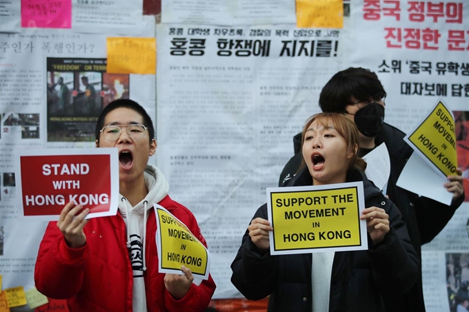 지난달 12일 오후 홍콩 민주화 시위를 지지하는 대자보가 붙은 서울 성북구 고려대 정경대학 게시판 앞에서 노동자연대 고려대모임 학생들이 홍콩 시위를 지지하는 구호를 외치고 있다. 연합뉴스