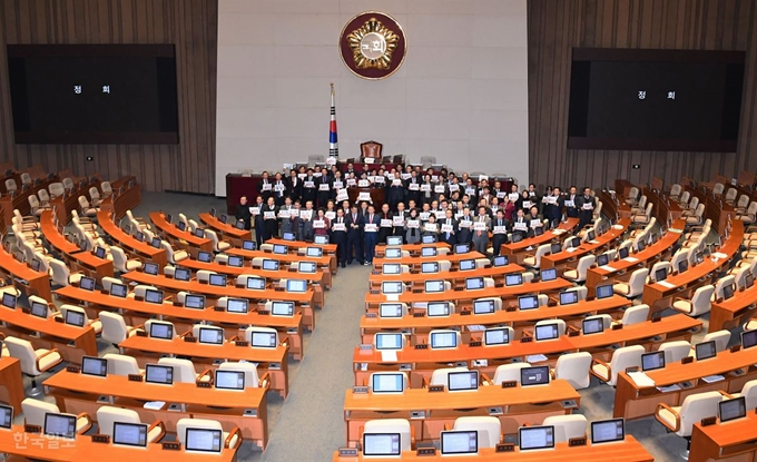 [저작권 한국일보]자유한국당 의원들이 10일 내년도 예산안이 통과된 직후 국회 본회의장에 남아 피켓을 들고 날치기 통과를 규탄하는 구호를 외치고 있다. 배우한 기자