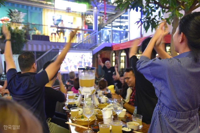 호찌민시 타오디엔 지역에 자리잡은 한 호프집에서 축구 경기를 관람하던 각국의 주재원들이 베트남 사람들과 함께 열광하고 있다. 호찌민=정민승 특파원/2019-12-11(한국일보)