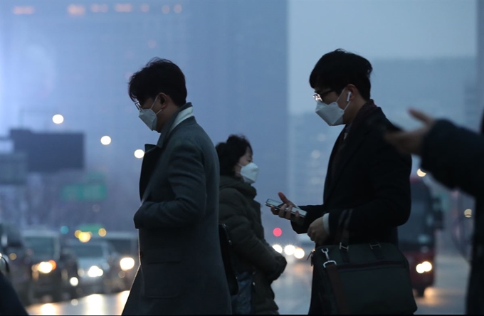 전국 미세먼지 농도가 ‘나쁨’에서 ‘매우 나쁨’ 수준을 보일 것으로 예보된 11일 오전 마스크를 낀 시민들이 서울 세종로 네거리 횡단보도를 건너고 있다. 연합뉴스