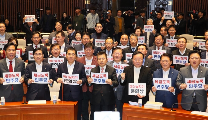 자유한국당 황교안 대표, 심재철 원내대표 등 의원들이 11일 국회에서 열린 의원총회에서 손팻말을 들고 "세금도둑 민주당, 예산날치기 문희상"을 외치고 있다. 연합뉴스