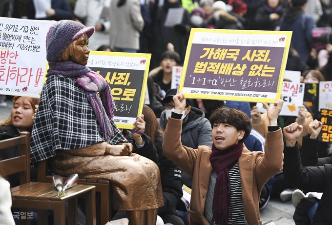 제1417차 정기 수요 집회가 열린 11일 오후 집회 참가자들이 '문희상 안'의 철회를 촉구하는 내용의 손팻말을 들고 있다. 박형기 인턴기자