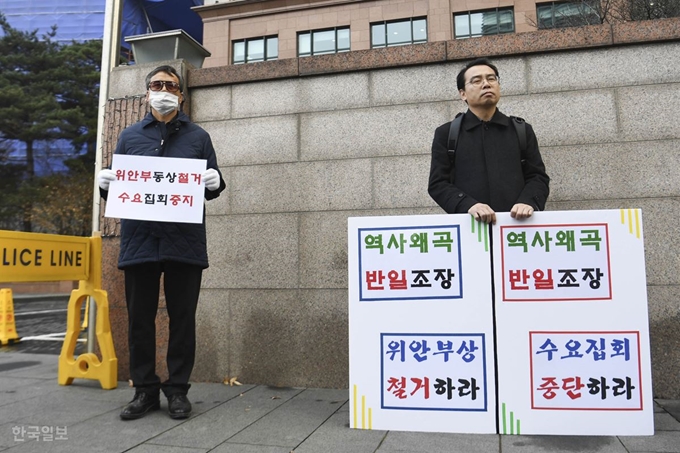 제1417차 정기 수요 집회가 열린 11일 오후 서울 종로구 옛 일본대사관 앞에서 반일 종족주의 공동 저자인 이우연 낙성대경제연구소 연구위원(오른쪽)이 수요집회 중단과 소녀상 철거를 주장하는 내용의 손팻말을 들고 있다. 박형기 인턴기자