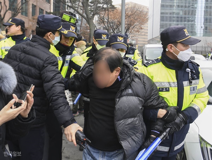 제1417차 정기 수요 집회가 열린 11일 오후 서울 종로구 옛 일본대사관 앞에서 한 시민이 수요집회 중단과 소녀상 철거를 주장하는 반일종족주의 공동 저자 이우연 낙성대경제연구소 연구위원의 손팻말을 부수고 난 후 경찰에게 끌려나가고 있다. 박형기 인턴기자