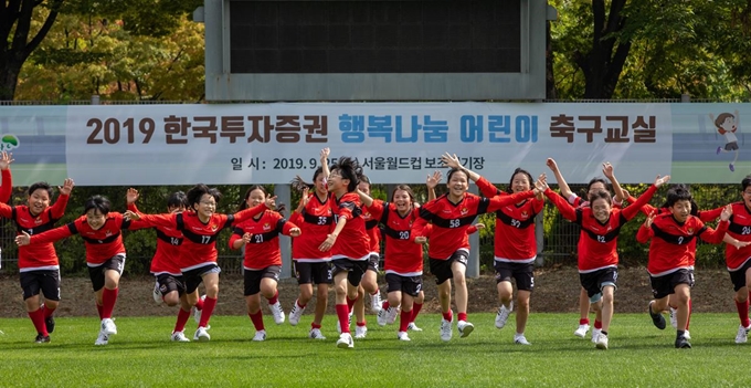 지난 9월25일 한국투자증권 주최로 서울 마포구의 서울월드컵보조경기장에서 진행된 '행복나눔 어린이 축구교실'에서 양천구 계남초등학교 학생들이 함께 운동장을 달리고 있다. 한국투자증권 제공