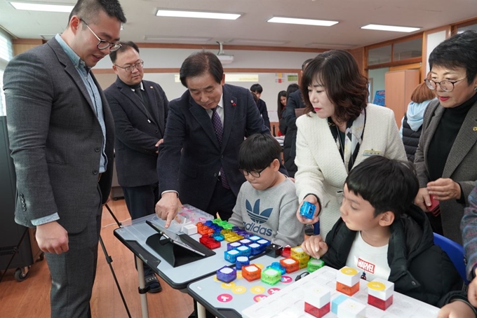 송기섭(왼쪽에서 세번째)진천군수가 16일 오후 진천 이월초등학교 스마트 교실을 찾아 디지털 교과서 등 첨단 교구로 수업하는 학생들을 격려하고 있다. 스마트교실은 개인 스마트패드, 상호작용형 스마트보드, 3D프린터, 햄스터로봇, 드론 등 첨단 기자재를 두루 갖추고 있다. 진천군 제공