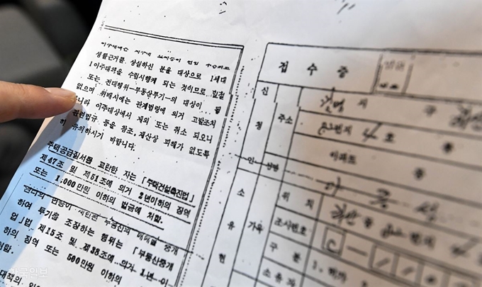 [저작권 한국일보] 철거상인 구자태씨가 1988년 대한주택공사 명의의 상가분양권 접수증 복사본을 보여주고 있다. 접수증 뒷면에 ‘일절 전매 또는 전대행위-부동산투기-의 대상이 될 수 없으며’라는 문구가 선명하다. 사진에 보이지 않는 아래 부분에는 주택건설촉진법을 언급하며 이주대책의 일환으로 공급받은 ‘아파트 등’을 전매하면 처벌되고 환매 된다고 명시해 놓았다. 서재훈 기자 spring@hankookilbo.com