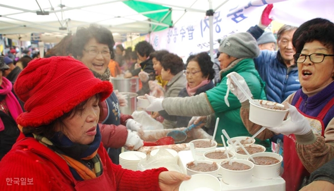 경북 예천불교사암연합회 자원봉사자들이 17일 동지를 앞두고 예천읍 천보당 사거리에서 용문사를 비롯한 관내 사찰에서 준비한 팥죽 5,000그릇을 군민들에게 나눠주고 있다. 올해 11회째 연례행사로 이어지는 '자비나눔 동지 팥죽공양' 행사는 팥죽을 먹으며 액운을 떨쳐내고 온정을 나누며 새해에 기쁜 일만 가득하기를 기원하는 자리다. 이날 행사에는 용문사 청안스님, 보문사 도안스님, 김학동 예천군수, 신동은 예천군의장 등이 동참했다. 이용호 기자