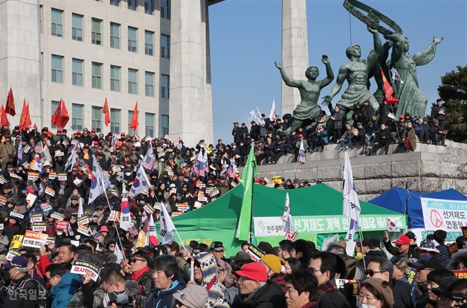 16일 오전 서울 여의도 국회 본청 계단 앞에서 열린 자유한국당 ‘공수처법 선거법 날치기 저지 규탄대회’와 우리공화당 당원들이 본청 앞 현관에서 태극기를 흔들며 패스트트랙 법안반대를 주장하고 있다. 오대근 기자