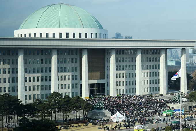 자유한국당의 ‘패스트트랙 법안 날치기 상정 저지 규탄대회’에 참가했던 보수단체 회원들이 16일 오후 서울 여의도 국회 본청 앞에서 선거법·공수처법 반대 구호를 외치며 집회를 계속하고 있다. 홍인기 기자