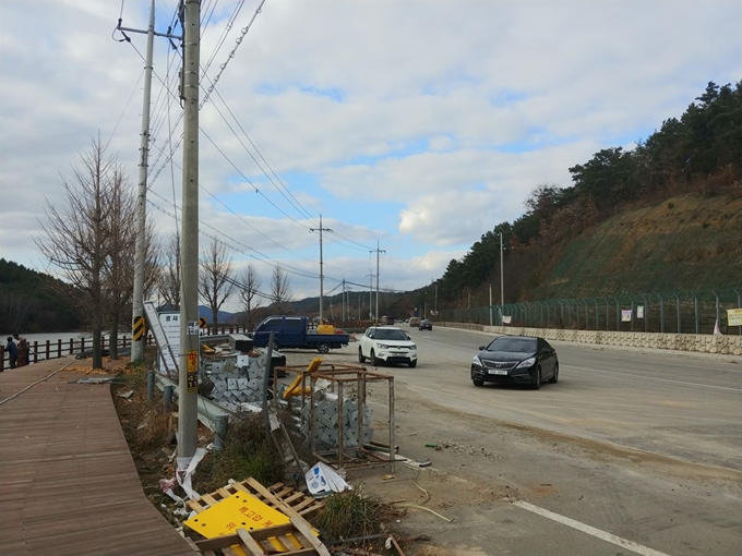 군위군이 부계면 수목원 인근 생태공원 주변 전선 지중화 사업을 하고 있다. 한전은 조만간 수목원 입구 쪽 도로에 박힌 전신주 22개를 철거하고 1,018m에 이르는 전선을 땅에 묻을 예정이다. 권성우 기자 ksw1617@hankookilbo.com