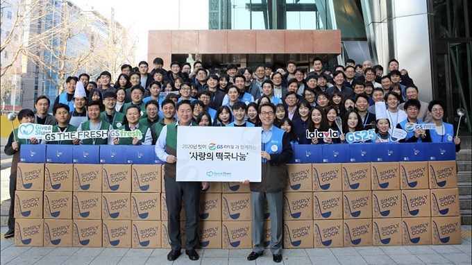 허연수(맨 앞줄 왼쪽) GS리테일 부회장과 조윤성 GS리테일 사장(오른쪽)을 비롯한 임직원들이 18일 서울 강남구 역삼동 GS타워에서 '떡국 5,000인분 나눔 릴레이'를 기념하는 단체사진을 찍고 있다. GS리테일은 이날부터 한 달 간 전국의 복지관과 보육원에 떡국 5,000인분을 전달하는 봉사활동을 펼친다. GS리테일 제공