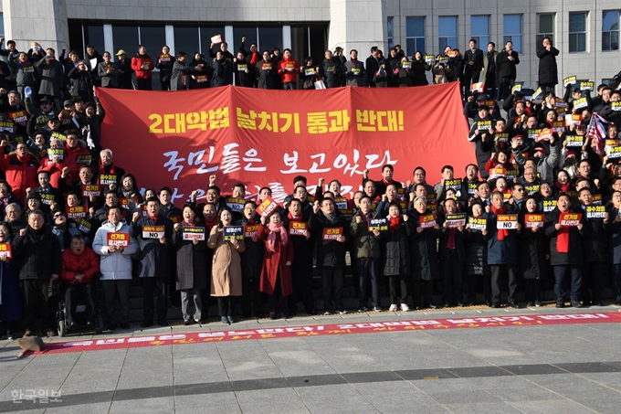 자유한국당 황교안 대표, 심재철 원내대표를 비롯한 의원 및 당원들이 20일 오후 국회 본관 앞 계단에서 열린 공수처법ㆍ선거법 날치기 저지 규탄대회에서 구호를 외치고 있다. 오대근기자