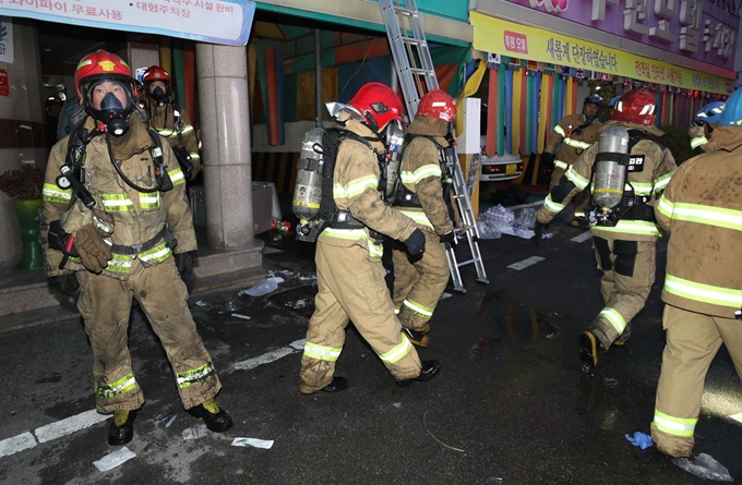 22일 오전 광주 북구 두암동 한 모텔에서 불이 나 경찰과 소방대원들이 인명 구조 작업을 하고 있다. 소방대원들이 연기를 마신 투숙객들을 구조한 뒤 내부에 투숙객이 남아 있는지 확인하기 위해 수색하고 있다. 연합뉴스