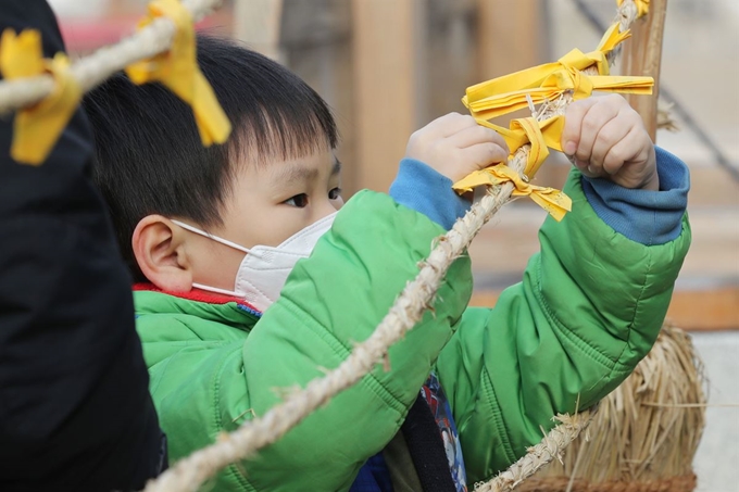 '작은 설 동지 행사'에서 한 어린이가 부적을 매듭지어 줄에 걸고 있다. 연합뉴스