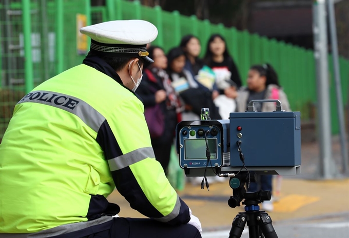 대전 둔산경찰서 관계자가 11일 오후 서구 둔산동 한 초등학교 앞 어린이보호구역(스쿨존)에서 과속 차량을 단속하고 있다. 국회는 전날 스쿨존에 과속단속 카메라 설치를 의무화하고, 스쿨존 내 사망사고 가해자를 가중처벌하는 것을 골자로 하는 ‘민식이법’을 상정·처리했다. 연합뉴스