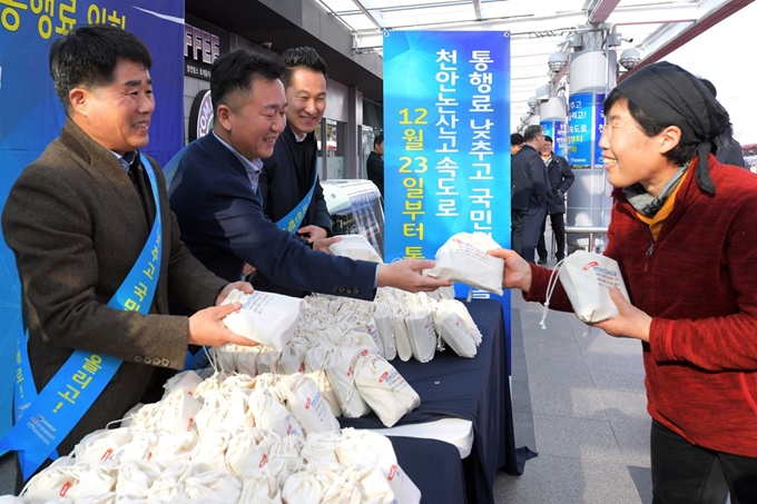 천안논산고속도로 전구간의 통행료를 최대 48% 인하한 23일 충남 공주시 정안휴게소에서 임직원들이 휴게소를 방문한 시민에게 통행료 인하 홍보를 하며 기념품을 나눠주고 있다. 사진공동취재단