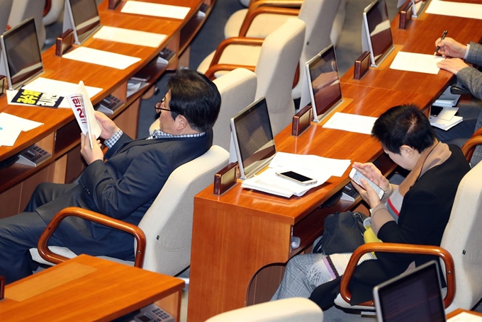 정양석 한국당 의원이 24일 오전 서울 여의도 국회에서 예산부수법안과 공수처법, 유아교육법 개정안 등을 안건으로 열린 본회의에서 권성동 의원이 필리버스터 발언을 하는 동안 독서를 하고 있다. 박인숙 의원은 휴대폰을 보고 있다. 뉴시스