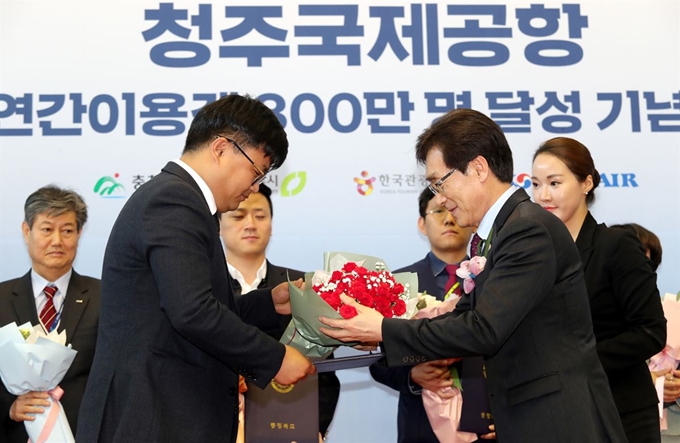 24일 청주국제공항 국제선 여객청사 1층에서 열린 청주공항 연간 이용객 300만명 돌파 기념식에서 이장섭(오른쪽) 충북정무부지사가 한국공항공사 관계자에게 축하 꽃다발을 전달하고 있다. 충북도 제공