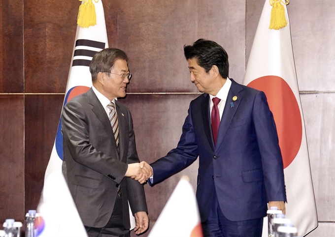 문재인 대통령과 아베 일본 총리가 24일 중국 쓰촨성 청두 세기성 샹그릴라호텔에서 악수하며 인사를 나누고 있다. 청두=연합뉴스