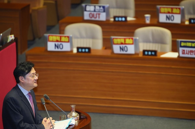 '공직선거법 개정안'에 대한 '무제한 토론'이 사흘째 이어진 25일 오전 국회 본회의장에서 홍익표 더불어민주당 의원이 '선거법 개정'에 반대하는 자유한국당 손팻말들을 배경으로 '찬성 토론'을 하고 있다. 연합뉴스