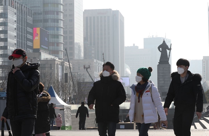 성탄절인 25일 서울 광화문광장에서 시민들이 미세먼지 마스크를 쓰고 있다.국립환경과학원은 이날도 수도권과 강원영서, 충청과 전북, 경북 지역 초미세먼지 농도가 '나쁨'을 이어갈 것으로 예보했다. 뉴스1