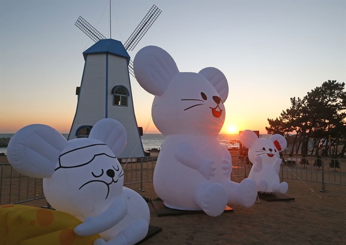 27일 오전 동해안 일출을 가장 먼저 볼 수 있는 울산시 울주군 서생면 간절곶에서 흰 쥐 조형물 너머로 해가 뜨고 있다. 2020년은 경자년(庚子年)으로 흰 쥐의 해다. 연합뉴스