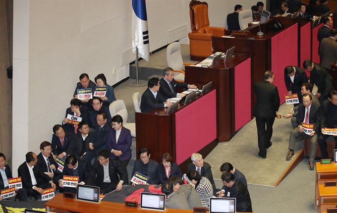 '공직선거법 개정안' 본회의 투표를 앞두고 27일 국회 본회의장에서 자유한국당 의원들이 손팻말을 든 채 국회 의장석 주변을 둘러싸고 있다. 연합뉴스