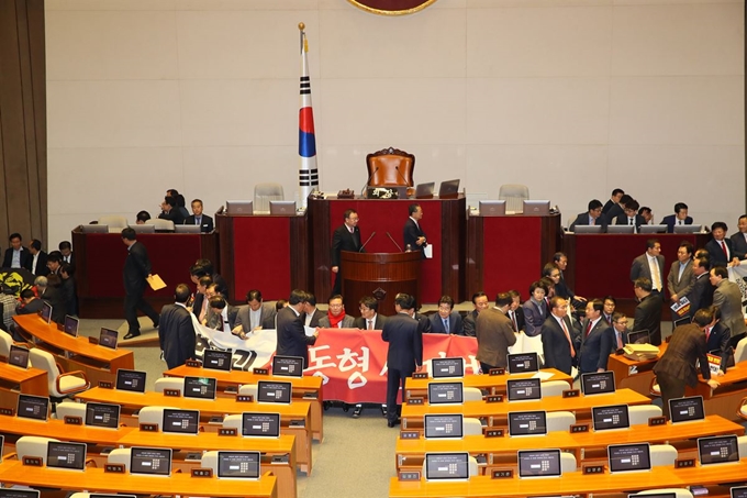 '공직선거법 개정안' 본회의 투표를 앞두고 27일 국회 본회의장에서 자유한국당 의원들이 플래카드를 펼치며 국회 의장석을 둘러싸고 있다. 연합뉴스