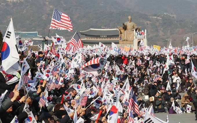 28일 오후 서울 광화문광장에서 문재인하야범국민투쟁본부 주최로 열린 대한민국 바로세우기 국민대회에서 참가자들이 태극기와 성조기를 흔들며 구호를 외치고 있다. 연합뉴스