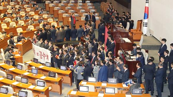 자유한국당 의원들이 30일 오후 본회의가 열리기에 앞서 국회 본회의장 의장석 앞에서 공수처 법안 반대 현수막을 펼치고 구호를 외치고 있다. 의장석 좌우에는 국회 직원들이 문희상 의장 등의 이동 통로를 확보하기 위해 자리잡고 있다. 연합뉴스