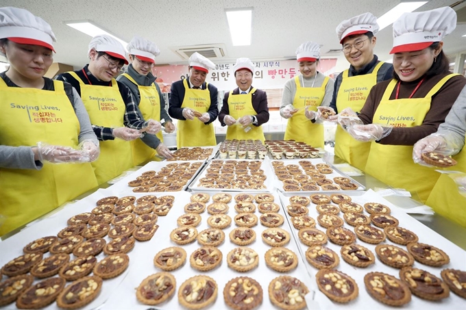 2일 부산 부산진구 부산적십자사 9층 희망나눔봉사센터에서 임직원들이 시무식으로 빵 나눔 봉사활동을 하고 있다. 부산적십자사는 한 해를 여는 행사로 딱딱한 시무식 대신 소외계층에 전달할 제빵 봉사활동을 마련했다. 부산=연합뉴스