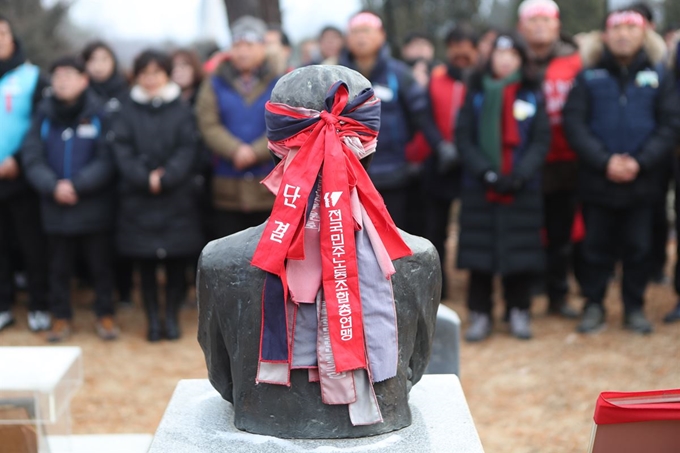 2일 경기도 남양주시 모란공원 전태일 열사 묘역에서 열린 전국민주노동조합총연맹 2020년 시무식에서 전태일 흉상의 색 바랜 머리띠 위에 새로운 머리띠가 둘러져 있다. 올해는 전태일 열사 분신 항거 50주년인 해다. 남양주=연합뉴스