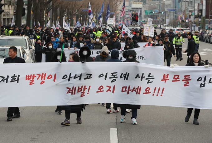 지난달 28일 오후 서울 종로구 청운효자동주민센터 인근에서 서울맹학교 학부모와 졸업생들이 ‘제발! 오지 마세요!!’를 적은 흰색 현수막을 들고 청와대로 향하는 보수단체의 행진을 막아서고 있다. 연합뉴스