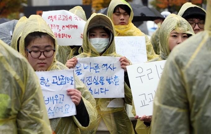 권력자는 역사를 자기 입맛대로 재단하려는 유혹에 빠진다. 역사라는 상징자본을 내 편으로 만들면 권력의 정당성을 확보하기가 쉬워지기 때문이다. 지난 2015년 11월 서울 세종로 정부서울청사 앞에서 청소년단체 회원들이 박근혜정부가 추진해온 역사교과서 국정화 반대를 외치며 시위를 벌이고 있다. 한국일보 자료사진