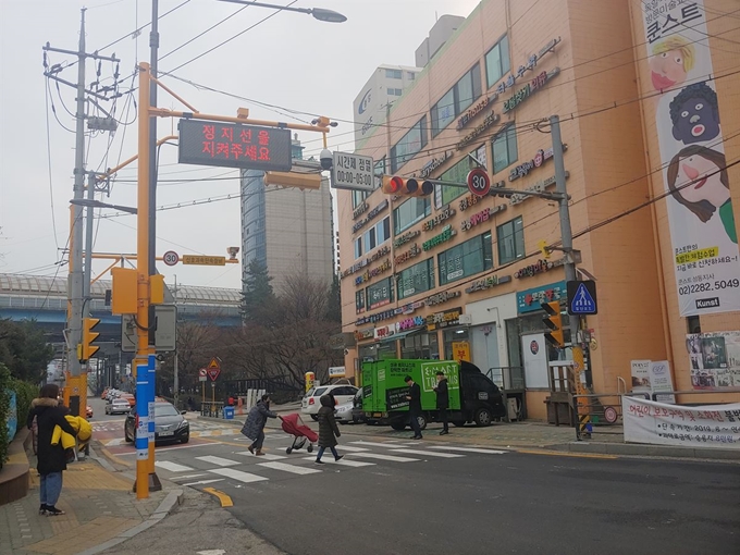 서울 성동구 옥정초 정문 앞에 설치된 ‘성동형 스마트횡단보도’를 주민들이 건너고 있다. 횡단보도 감시 폐쇄회로(CC) TV와 집중조명등, 활주로형 유도등, 보행 신호 음성안내 장치 등 교통사고 예방 기능을 갖추고 있다. 권영은 기자