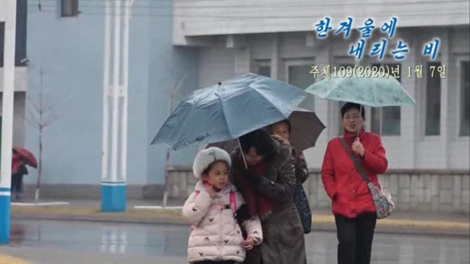 노동신문은 평양에 보기 드물게 겨울비가 내리고 있다고 8일 보도했다. 사진 속 붉은 옷을 입은 여성의 옷차림이 단촐하다. 평양=노동신문 연합뉴스